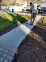 Applying the finishing layer of sand to this courtstone path at the Chain of Lakes waterfront remodel